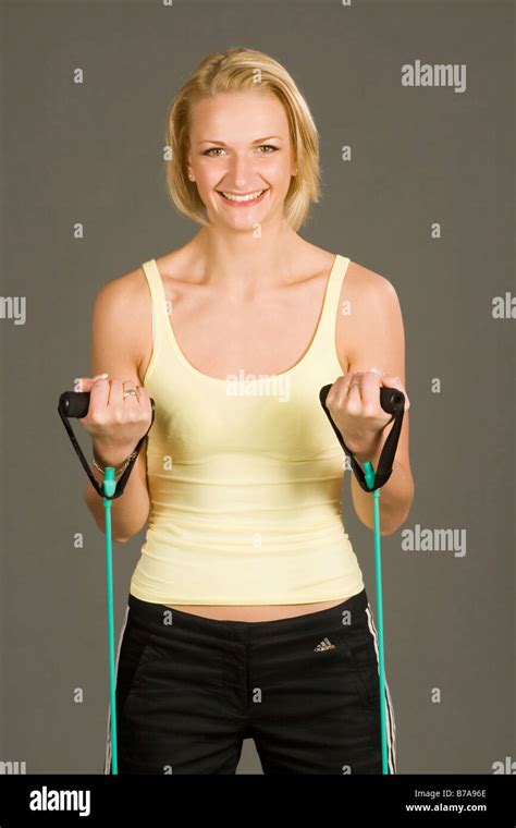 Junge blonde Frau trägt Sportbekleidung mit Röhren für Bodyforming und trainieren ihre Muskeln