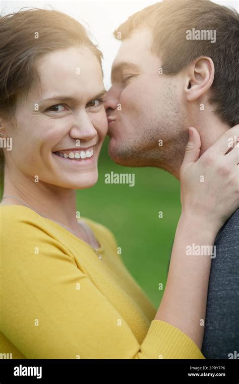 He Just Couldnt Resist Another Kiss A Happy Woman Receiving A Kiss From Her Husband Outside