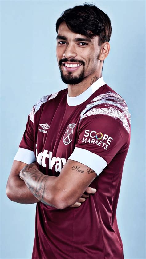 A Man With His Arms Crossed Wearing A Maroon And White Soccer Jersey