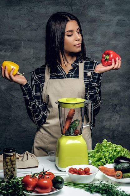 Free Photo Attractive Brunette Chef Woman Holds Colorful Sweet Peppers For Vegetable Cocktail