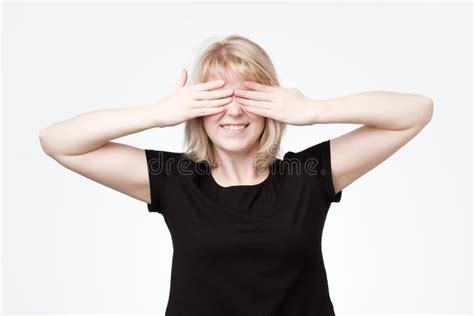 Woman Covering Eyes With Hands And Smiling Broadly Being Intrigued