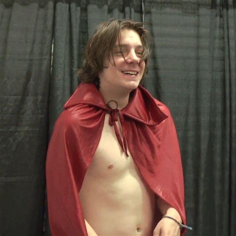 A Man In A Red Cape Standing Next To A Black Curtain With His Hands On His Hips