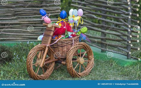 Triciclo De Mimbre Con La Cesta De Pascua En Hierba Foto De Archivo