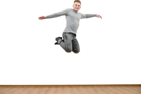 O Homem Feliz Pulando No Fundo Da Parede Branca Foto Premium