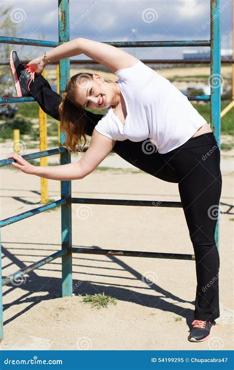 Muchacha Que Hace Estirando Ejercicio Cerca De La Barra Transversal