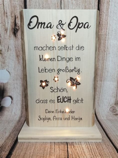 A Wooden Sign That Says Oma And Opa With Lights In The Shape Of Butterflies