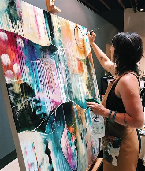 A Woman Is Painting On An Easel With Paint