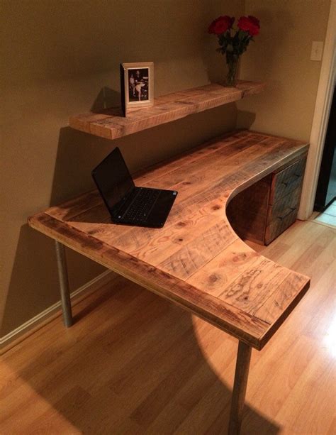 A Laptop Computer Sitting On Top Of A Wooden Desk Next To A Shelf