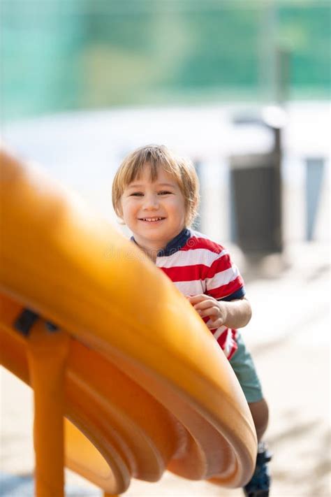 Cute Smiling Blonde Boy Climbing Up The Slide And Looking In The Camera Stock Photo Image Of