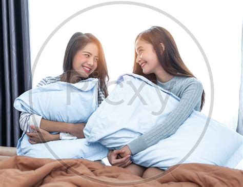 Image Of Two Asian Lesbian Women Looking Together In Bedroom Couple