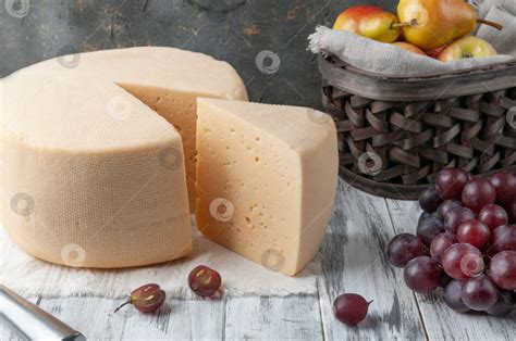 От круглой головки сыра отрезается треугольный кусочек. Сыр - Ozero ...