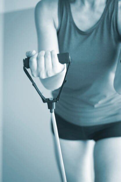 Premium Photo | Midsection of woman exercising with resistance band in gym