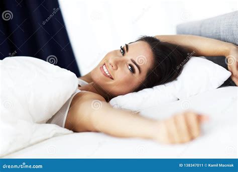 Young Beautiful Woman Waking Up In Her Bed Fully Rested Stock Image