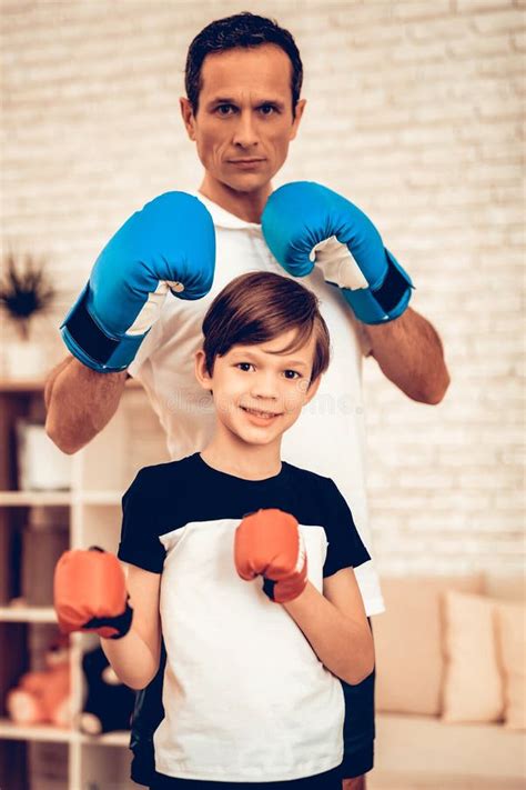 Muchacho Sonriente Con El Hombre En Guantes De Boxeo Rojos Y Azules Foto De Archivo Imagen De