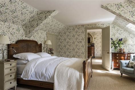 A bedroom in the eaves brightened up by classic wallpaper and the ...