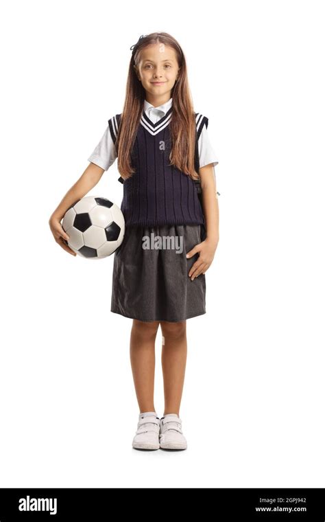 Full length portrait of schoolgirl in a uniform holding a football isolated on white background ...