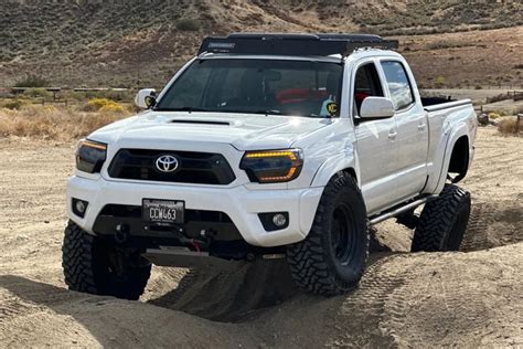 A White Truck Is Driving Through The Sand