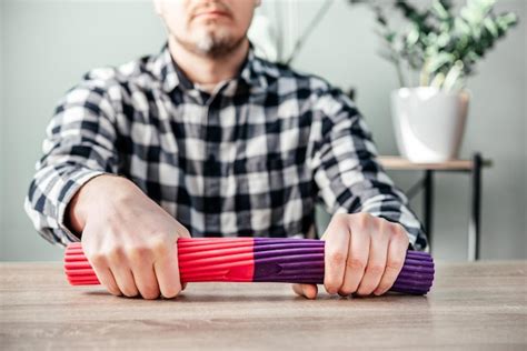 Premium Photo | A man doing wrist exercises with theraband flexbar