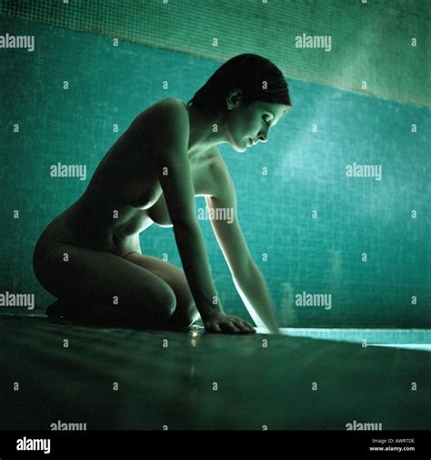 Nude Woman Kneeling By Side Of Swimming Pool Stock Photo Alamy