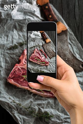 Photographing Food Concept Woman Takes Picture Of Raw Dry Aged T Bone