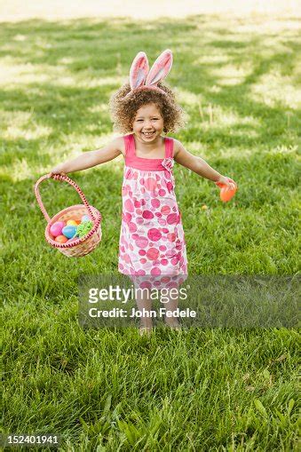 Mixed Race Girl Holding Basket Of Easter Eggs High Res Stock Photo