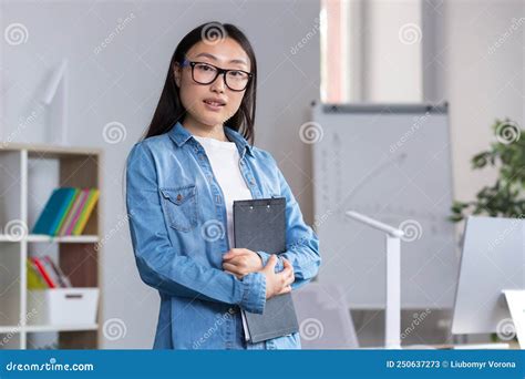 Young Beautiful Asian Female Teacher Looking At The Camera And Smiling