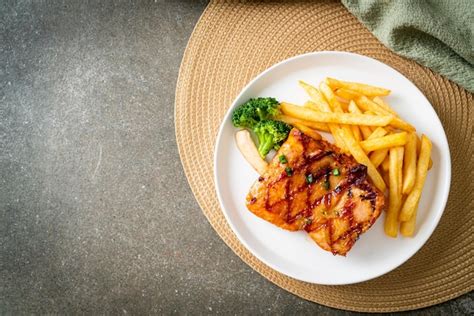 Premium Photo | Grilled chicken steak with potato chips or french fries