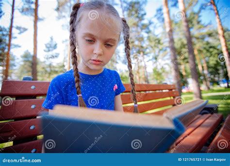 Cute Little Girl is Reading a Book Outdoors Stock Image - Image of cute ...