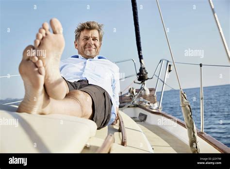 Portrait Of Smiling Mature Man Lying On Deck Of His Sailing Boat Stock Photo Alamy