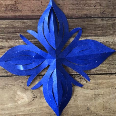 A Blue Paper Flower On A Wooden Surface