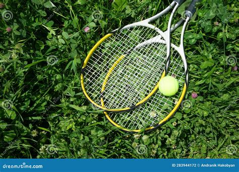 Tennis Ball And Racket On The Green Grass Background Stock Photo