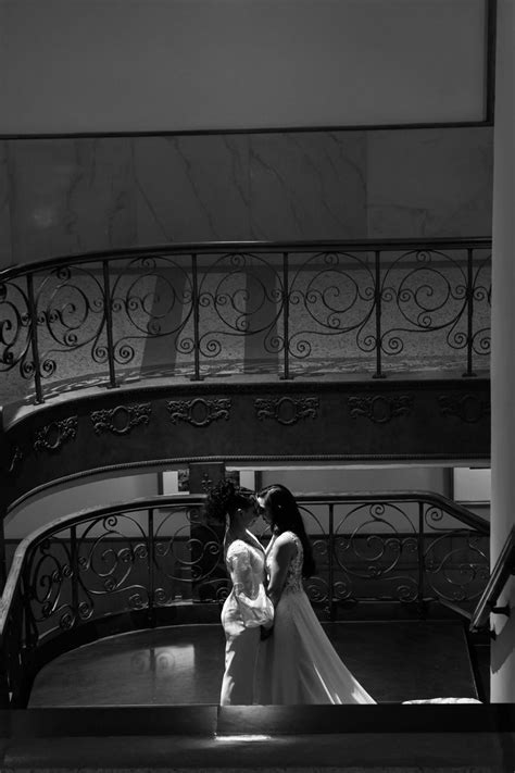 The Bride And Groom Are Kissing On The Stairs At Their Wedding