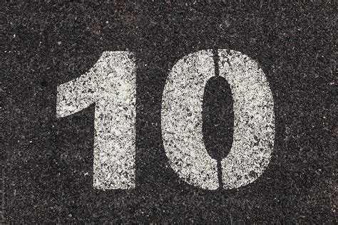 Number Printed On White Over Dirty Asphalt By Stocksy Contributor