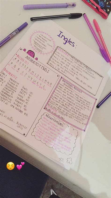 A Pink Notebook With Writing On It Sitting Next To Some Pens And Pencils