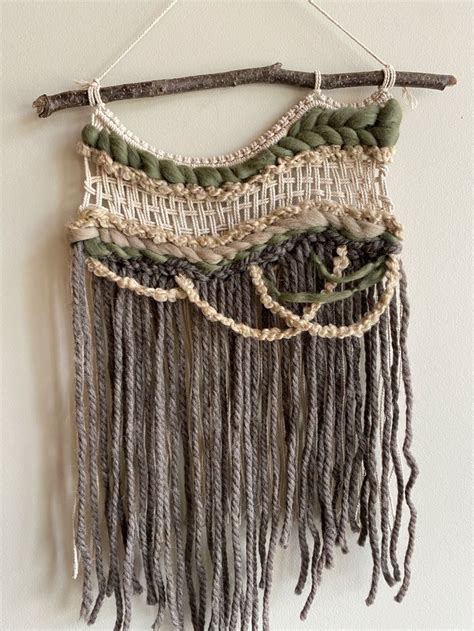 A Wall Hanging Made Out Of Yarn And Wood Sticks With Some Beads On It