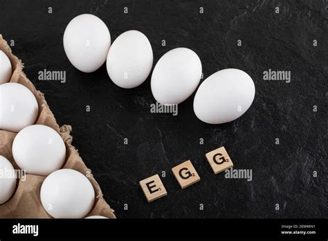 Cardboard Egg Box With White Chicken Eggs On A Black Background Stock