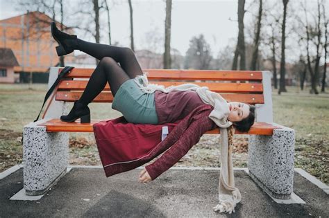 Premium Photo Beautiful Portrait Of A Pretty Brunette Girl Laying On The Bench With Her Legs