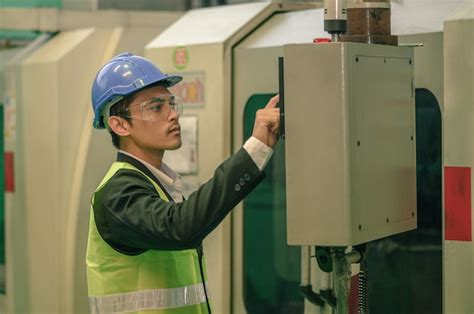 O homem de engenharia verificando as máquinas dentro da fábrica