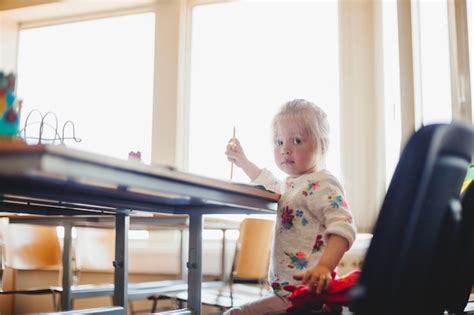 Blonde M Dchen Sitzt Am Tisch Mit Bleistift Kostenlose Foto