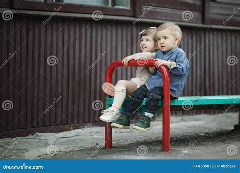 Menino E Menina Que Sentam Se No Banco Imagem De Stock Imagem De