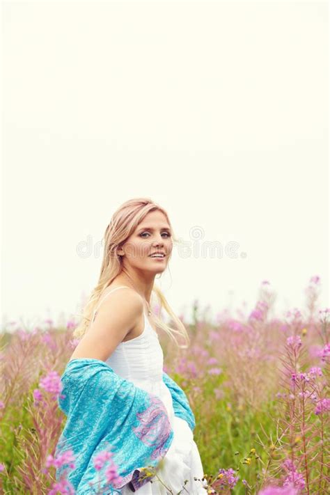 Outdoor Portrait Of A Middle Aged Blonde Woman Attractive Girl In A Field With Flowers Stock