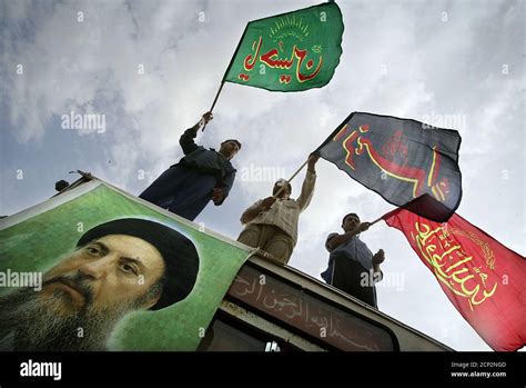 Iraqi Shi`ite Men Wave Flags Atop A Bus Decorated With Picture Of Their Spirutual Leader