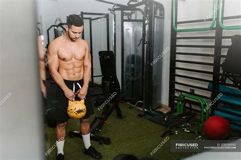 Athletic Male With Naked Torso Doing Exercises With Heavy Kettlebell During Active Training In