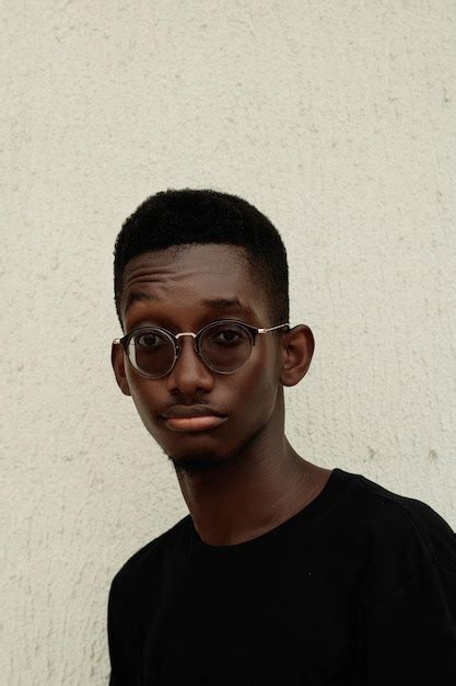 Premium Photo Portrait Of Young Man Wearing Sunglasses Against Wall