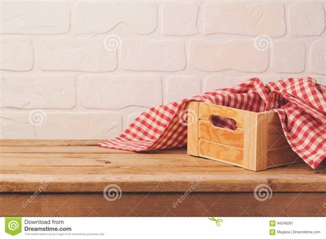 Empty Wooden Deck Table With Box And Tablecloth Over Brick Wall Stock