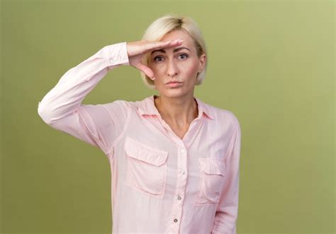 Jeune Femme Slave Blonde Regardant à Distance Avec La Main Isolée Sur Vert Olive Photo Gratuite
