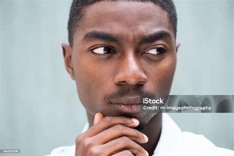 Close Up Serious Young African American Man Thinking With Hand To Chin