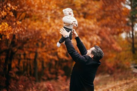 Premium Photo Dad Holds His Son In His Arms In The Autumn Park