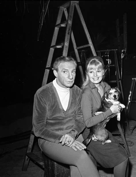 an old black and white photo shows a man holding a dog in his lap while ...