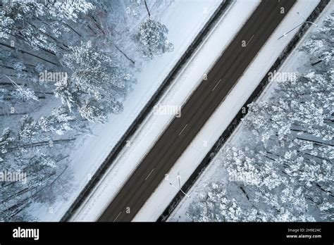 Aerial View Of Asphalt Highway Leading Through Frosty Winter Forests